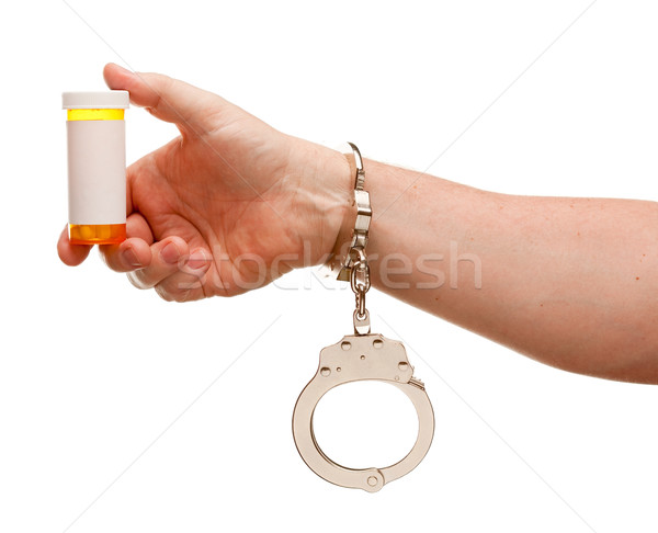 Handcuffed Man Holding Blank Medicine Bottle Isolated on White Stock photo © feverpitch