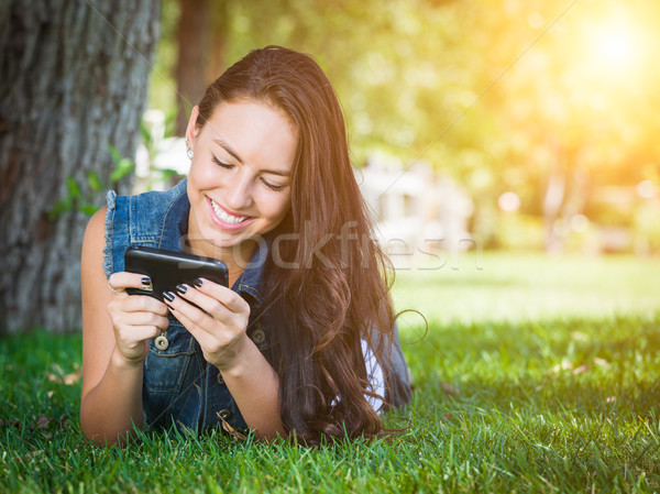 Mixed Race Young Female Texting on Cell Phone Outside In The Gra Stock photo © feverpitch