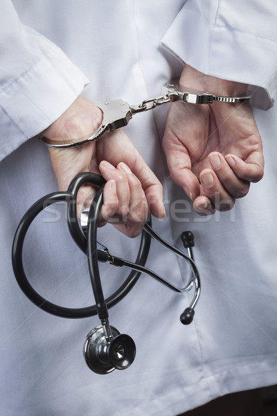 Female Doctor or Nurse In Handcuffs Holding Stethoscope Stock photo © feverpitch