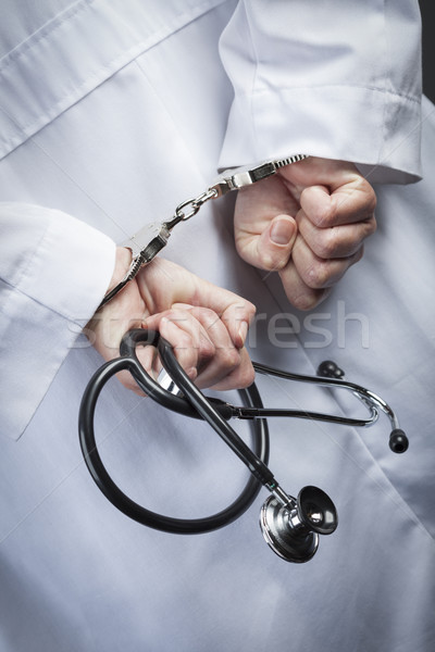 Female Doctor or Nurse In Handcuffs Holding Stethoscope Stock photo © feverpitch
