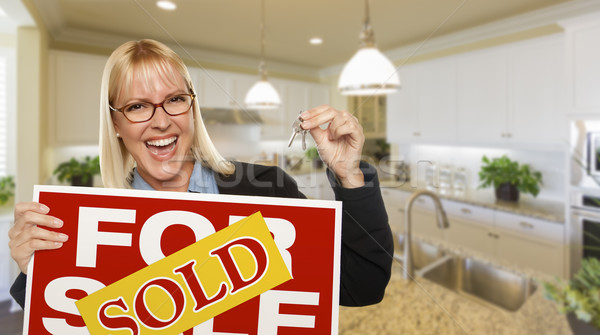 Stock photo: Young Woman Holding Blank Sign and Keys Inside Kitchen
