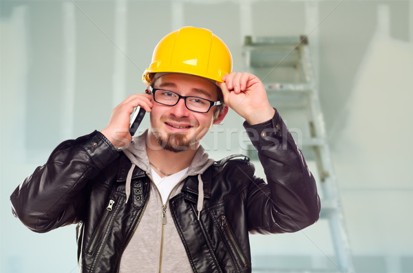 Contractor in Hard Hat on Cell Phone In Unfinished House Stock photo © feverpitch