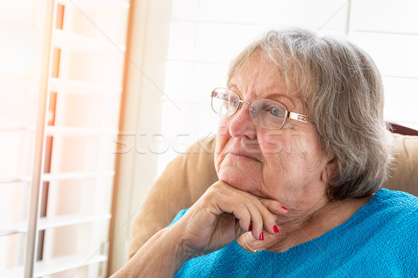 Contemplative Senior Woman Gazing Out of Her Window Stock photo © feverpitch