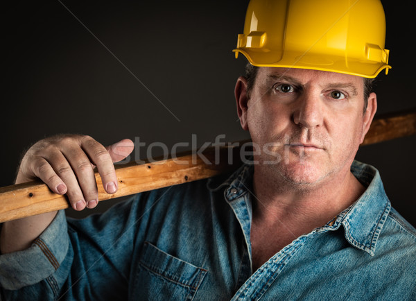 Serious Contractor in Hard Hat Holding Plank of Wood With Dramat Stock photo © feverpitch