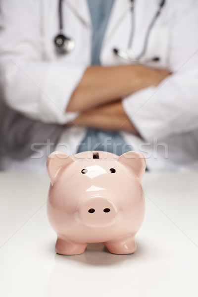 Foto stock: Médico · dobrado · brasão · atrás · piggy · bank · feminino