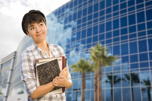 Mixed Race Female Student Holding Books in Front of Building Stock photo © feverpitch