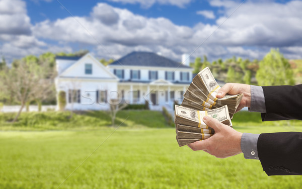 Man Handing Over Hundreds of Dollars in Front of House Stock photo © feverpitch