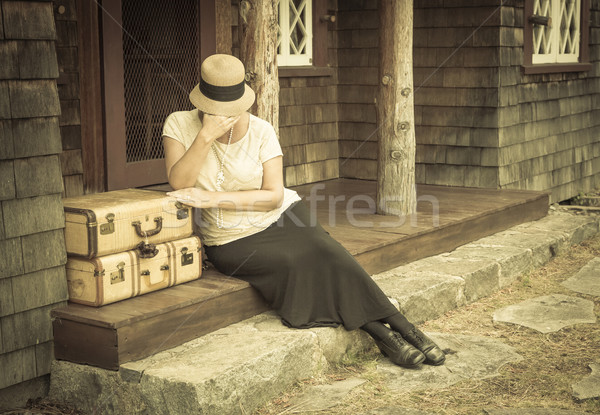 Stock photo: Distressed 1920s Girl Near Suitcases on Porch with Vintage Effec
