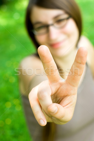 Mosolyog lány készít győzelem kézmozdulat fiatal nő Stock fotó © filmstroem