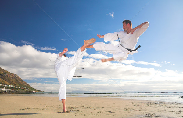 Men practicing Karate on the beach Stock photo © Forgiss