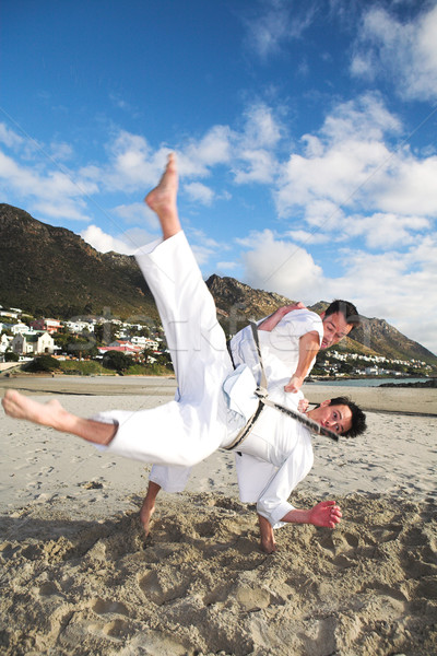 Men practicing Karate on the beach Stock photo © Forgiss