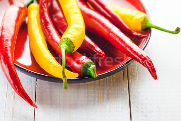 Piros citromsárga chilipaprika felszolgált tányér tűz Stock fotó © fotoaloja