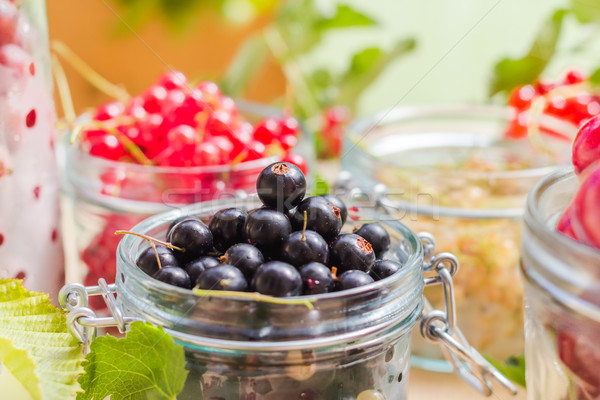 Stock photo: black red white currants gooseberries cherries jars preparations