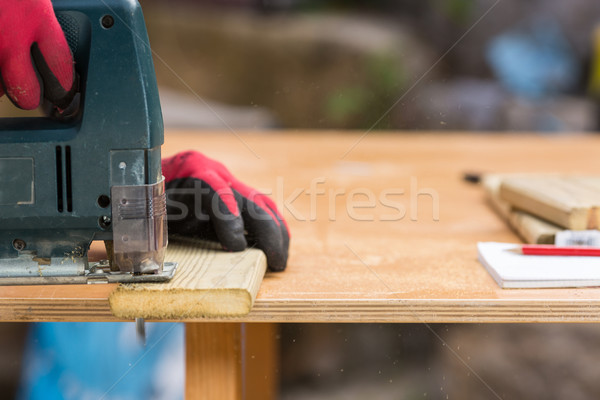 Carpenter sawing a board Stock photo © fotoedu