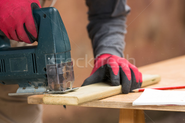 Carpenter sawing a board Stock photo © fotoedu