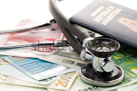 Bills with stethoscope and passport Stock photo © fotoquique