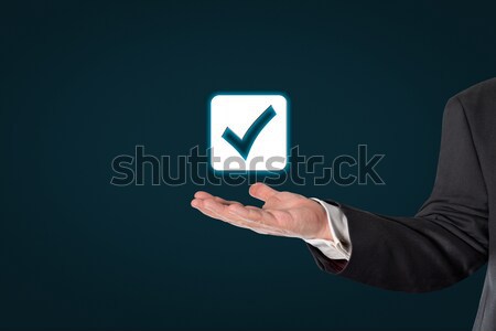 Businessman holding a virtual checked symbol Stock photo © fotoquique