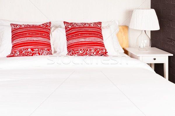 Red pillow on bedroom with white bed sheet and lamp Stock photo © FrameAngel
