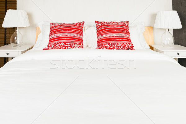 Red pillow on bedroom with white bed sheet and lamp Stock photo © FrameAngel