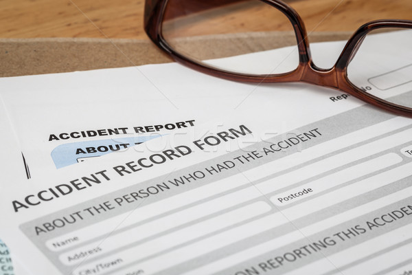 Accident report application form on brown envelope and eyeglass, Stock photo © FrameAngel