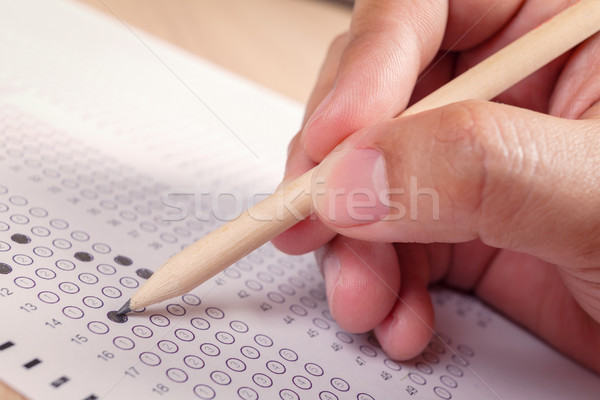 Stock photo: hand fill in Exam carbon paper computer sheet and pencil
