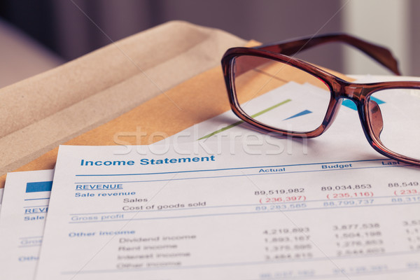 Income statement letter on brown envelope and eyeglass, business Stock photo © FrameAngel