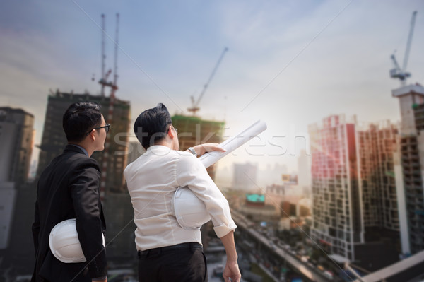 Asian businessman discuss with engineer architect in suite, looking and point to finger forward away Stock photo © FrameAngel