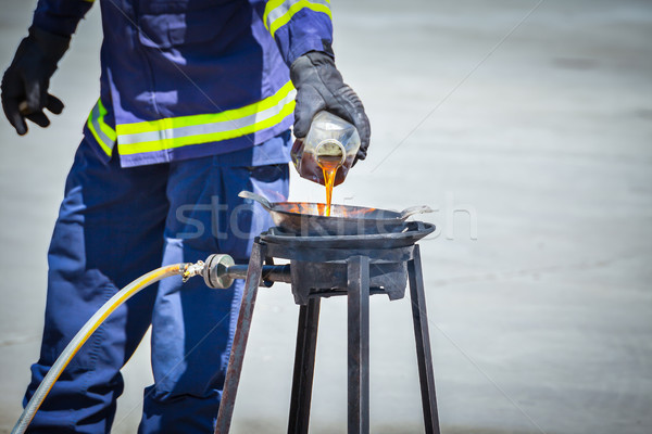 fire trainer teach pouring oil into pan flames for conflagration Stock photo © FrameAngel