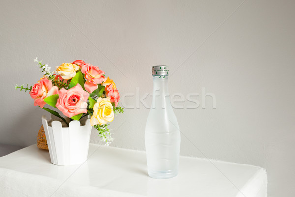 flower and bottle of water, on white table Stock photo © FrameAngel