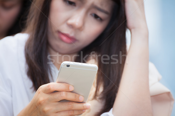 asian businesswoman using cell smart phone and confuse about bad Stock photo © FrameAngel