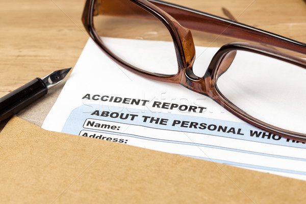 Accident report application form and pen on brown envelope and e Stock photo © FrameAngel