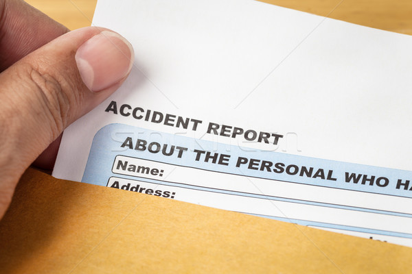 Accident report application form and human hand on brown envelop Stock photo © FrameAngel
