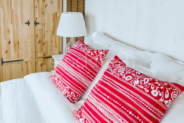 Red pillow on bedroom with white bed sheet and lamp Stock photo © FrameAngel