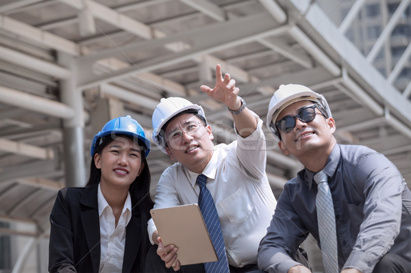 Asian businessman and woman discuss with engineer architect prof Stock photo © FrameAngel