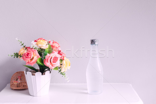 flower and bottle of water, on white table Stock photo © FrameAngel