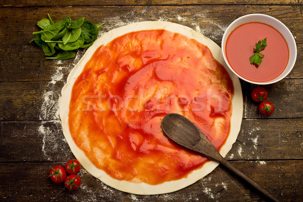 Pizza voorbereiding tomatensaus houten tafel brood bladeren Stockfoto © Francesco83