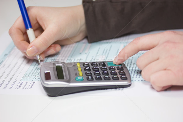 Filling income tax forms with calculator and pen Stock photo © frank11