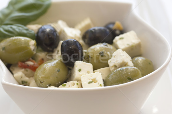 Salad of olives, served with chunks of cheese in a white bowl. Stock photo © frank11