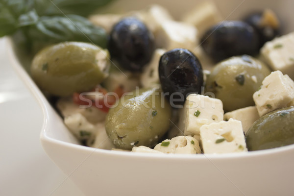 Salad of olives, served with chunks of cheese in a white bowl. Stock photo © frank11