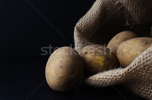 Potatoes Tipping from Hessian Sack on Black Stock photo © frannyanne