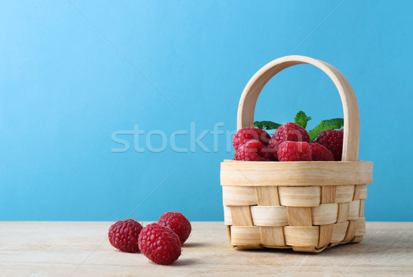 Basket of Raspberries against Blue Background Stock photo © frannyanne