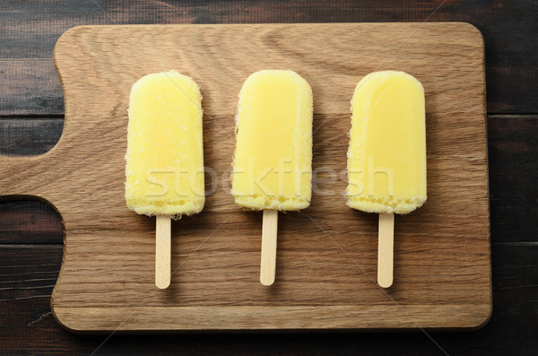 Row of Yellow Ice Lollies on Wood from Above Stock photo © frannyanne