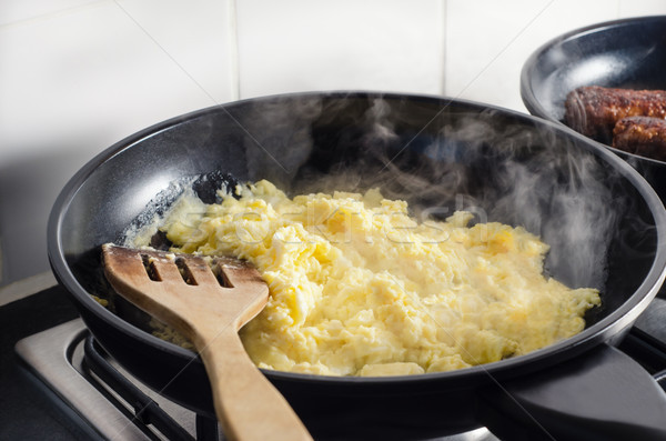Hot Scrambled Eggs and Vegetarian Sausages Cooking on Hob Stock photo © frannyanne