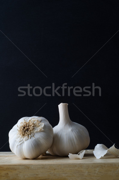 Two Garlic Bulbs on Wooden Chopping Board Stock photo © frannyanne