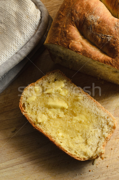Warm Home Baked Loaf of Bread with Cut Slice and Melting Butter Stock photo © frannyanne