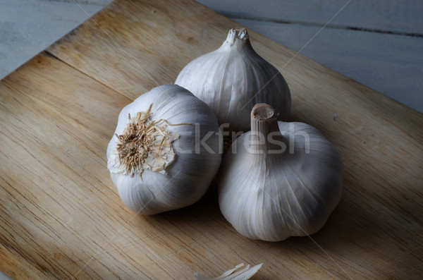 Three Whole Garlic Bulbs on Wooden Chopping Board Stock photo © frannyanne