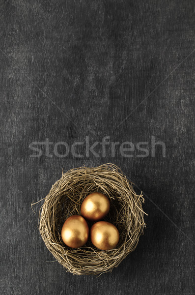 Overhead of Nest containing Three Gold Eggs on Chalkboard Backgr Stock photo © frannyanne