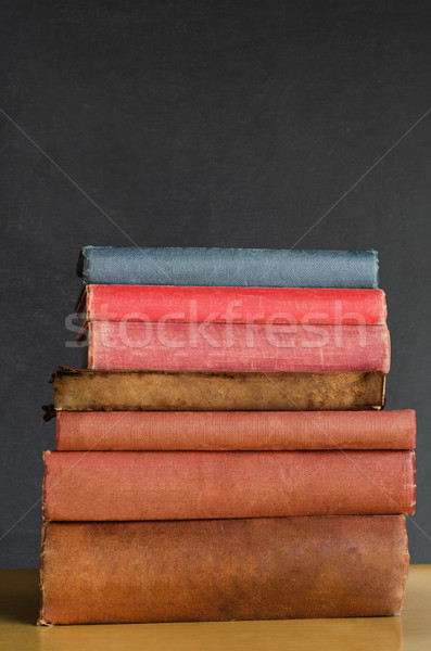 Books Stacked on Classroom Desk with Chalkboard Background Stock photo © frannyanne