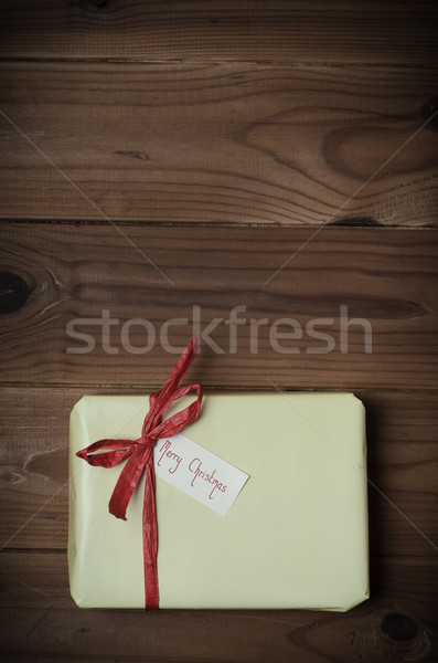 Wrapped Gift Package with Merry Christmas Label on Wood Planking Stock photo © frannyanne