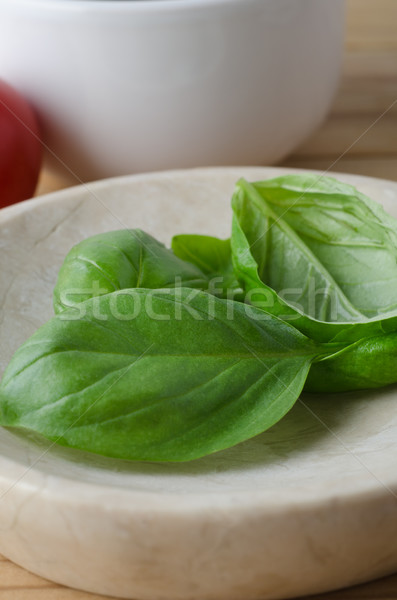 Whole Basil Leaves in close with Tomato in Background Stock photo © frannyanne